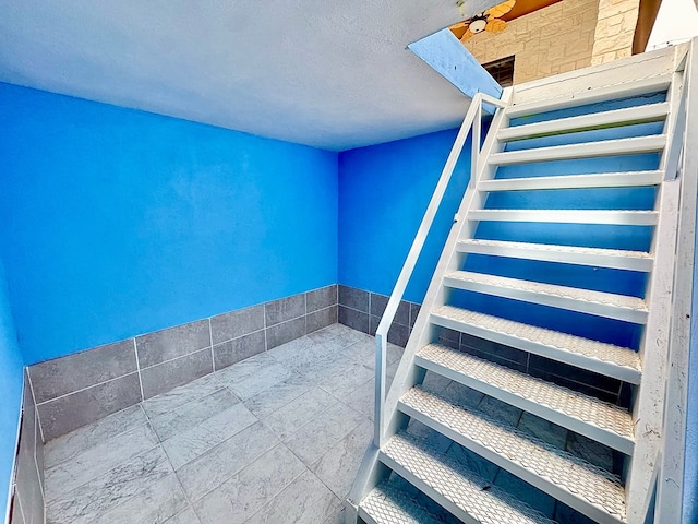 staircase with a textured ceiling