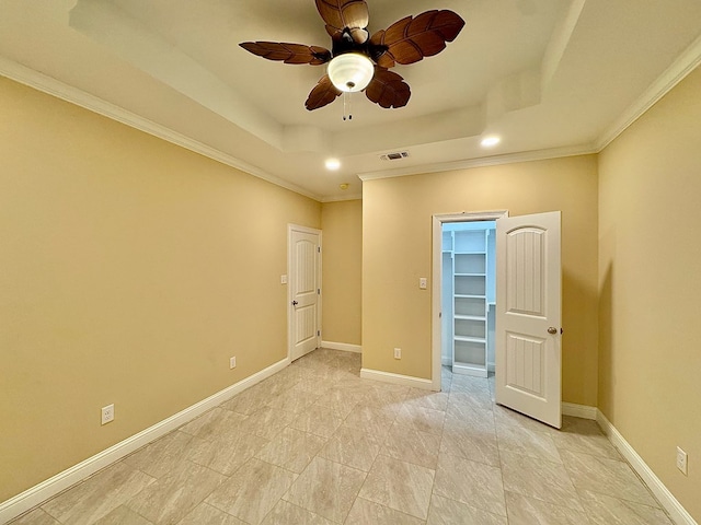 spare room featuring crown molding, a tray ceiling, and ceiling fan