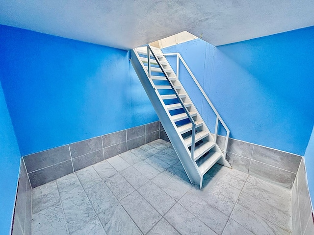 staircase with a textured ceiling