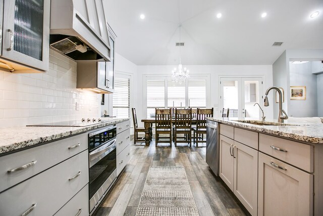 2118 Valleyview Dr, San Angelo, TX 76904 - kitchen featuring appliances with stainless steel finishes, premium range hood, a chandelier, lofted ceiling, and light stone counters