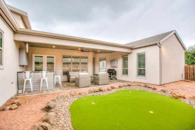 2118 Valleyview Dr, San Angelo, TX 76904 - back of property featuring stucco siding, a patio area, a ceiling fan, and a putting area
