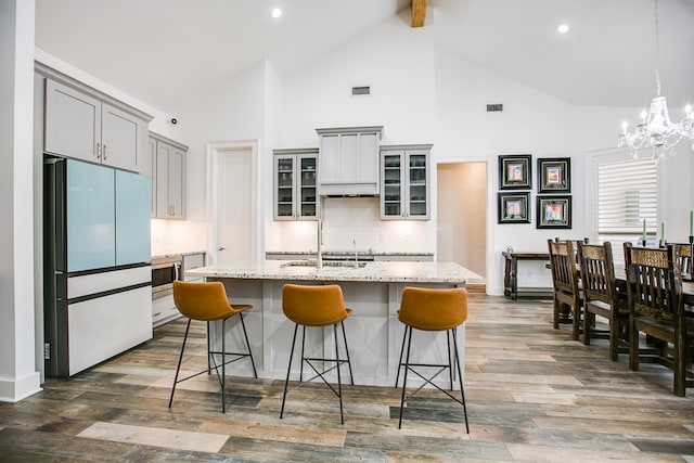 2118 Valleyview Dr, San Angelo, TX 76904 - kitchen with freestanding refrigerator, high vaulted ceiling, gray cabinetry, a kitchen bar, and a chandelier