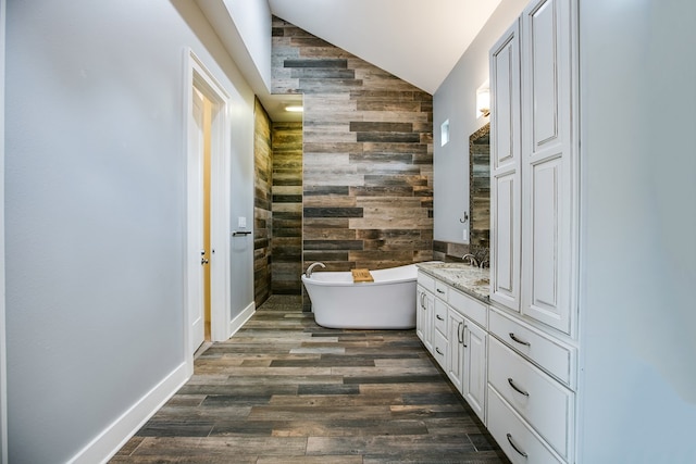 2118 Valleyview Dr, San Angelo, TX 76904 - full bath with vaulted ceiling, a freestanding tub, wood walls, vanity, and wood finished floors