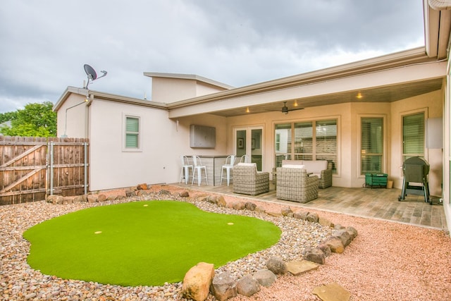 2118 Valleyview Dr, San Angelo, TX 76904 - back of property featuring a patio, an area to practice putting, stucco siding, ceiling fan, and french doors