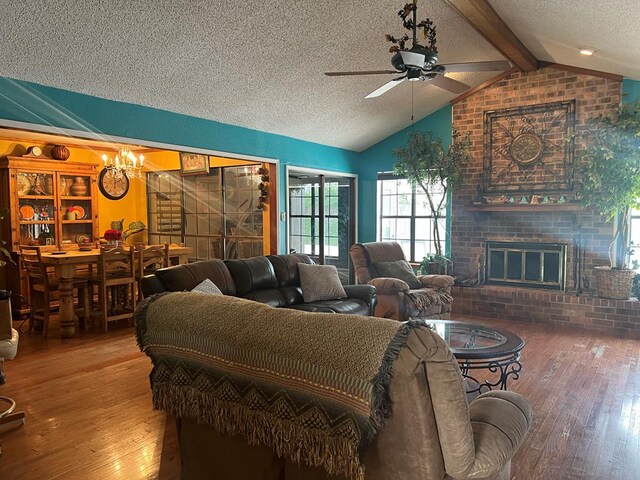 3826 Hillcrest Dr, San Angelo, TX 76904 - living room with a textured ceiling, lofted ceiling with beams, wood-type flooring, a brick fireplace, and ceiling fan with notable chandelier