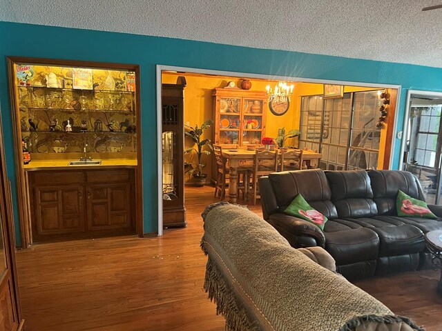 3826 Hillcrest Dr, San Angelo, TX 76904 - living area featuring indoor wet bar, a textured ceiling, a notable chandelier, and wood finished floors