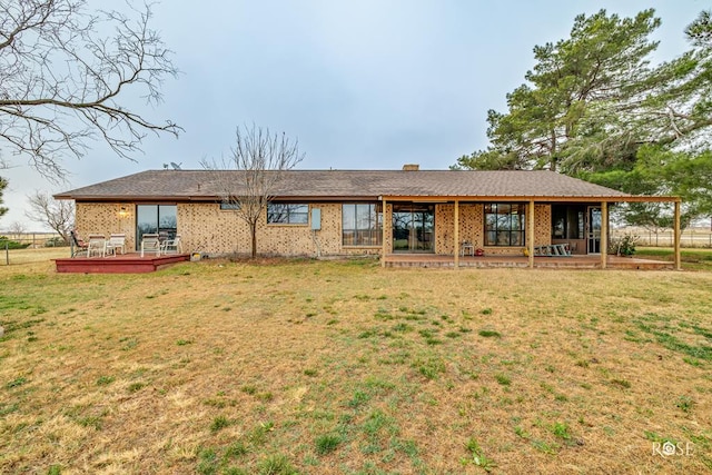 rear view of house featuring a wooden deck and a yard