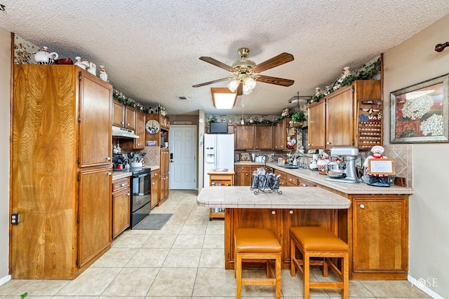 kitchen with a breakfast bar, sink, white fridge with ice dispenser, kitchen peninsula, and black range with electric cooktop