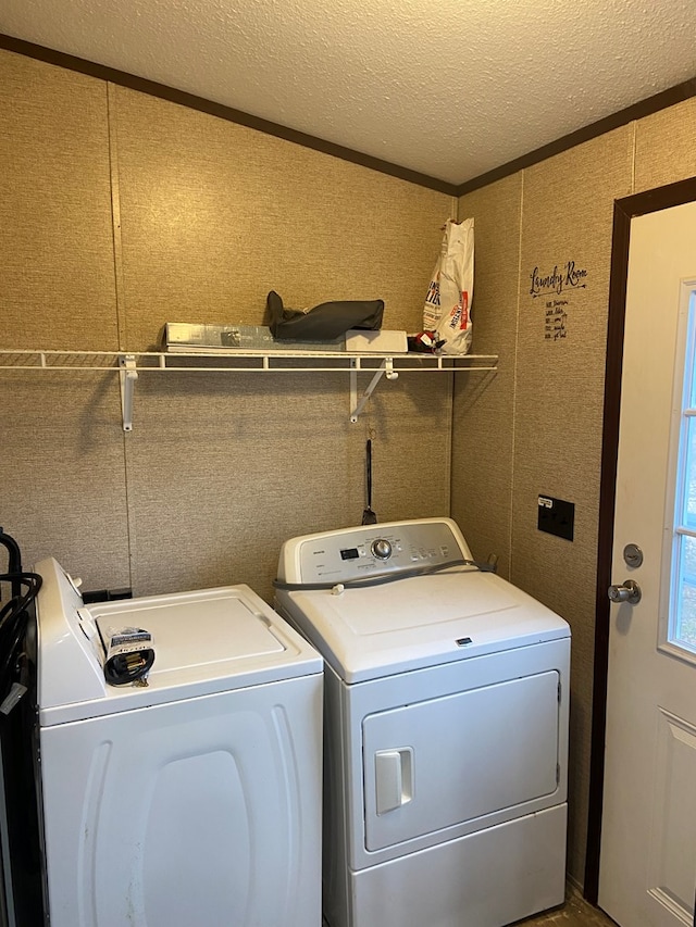 laundry room featuring washing machine and dryer and a textured ceiling