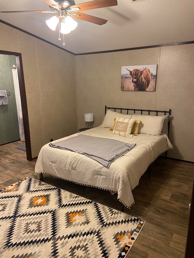 bedroom with crown molding, dark hardwood / wood-style flooring, and ceiling fan