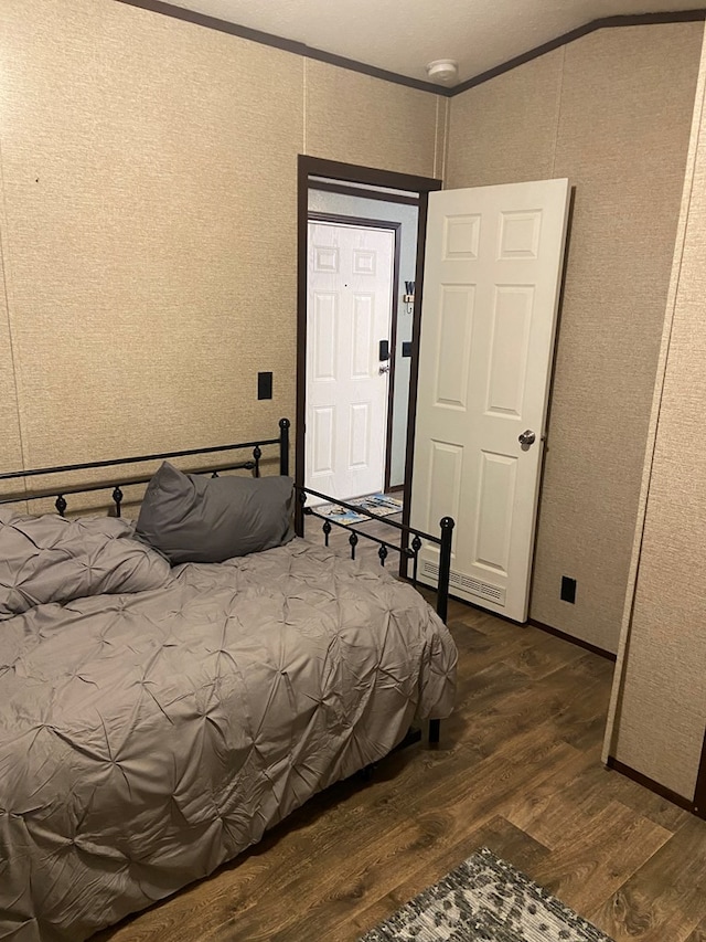 bedroom featuring crown molding and dark hardwood / wood-style flooring