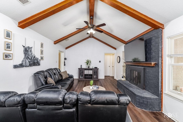 2509 1st Atlas St, San Angelo, TX 76905 - living area with dark wood-style flooring, a fireplace, a ceiling fan, and a textured ceiling