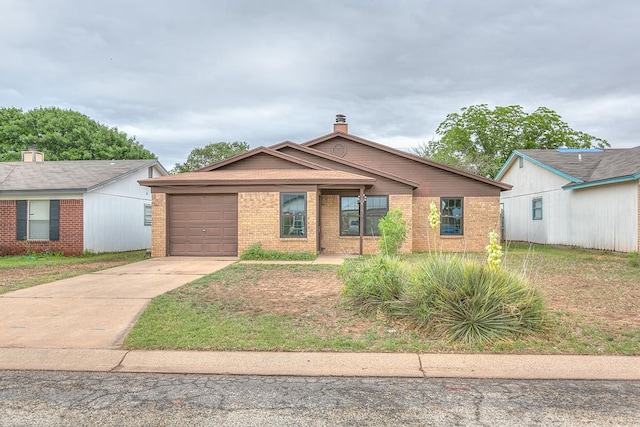 1826 High Butte Dr, San Angelo, TX 76905 - view of front facade with brick siding, driveway, a garage, and a chimney