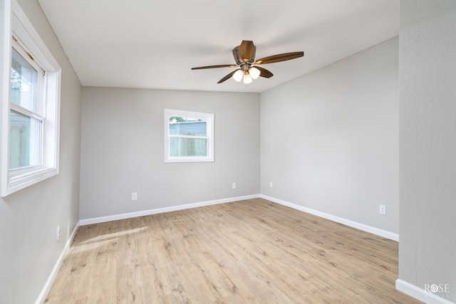 unfurnished room with lofted ceiling, a wealth of natural light, light hardwood / wood-style floors, and ceiling fan