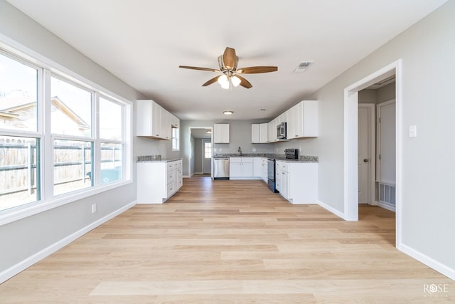 kitchen with white cabinetry, ceiling fan, stainless steel appliances, and light hardwood / wood-style floors