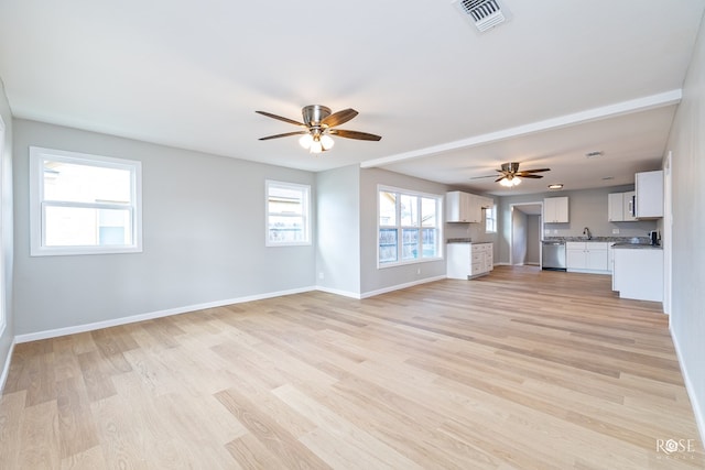 unfurnished living room with ceiling fan, sink, and light wood-type flooring