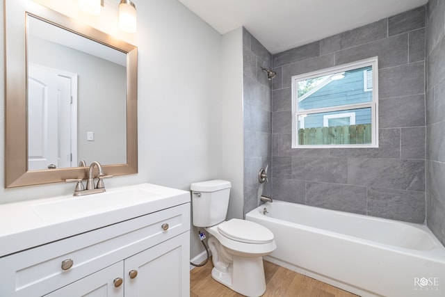 full bathroom featuring vanity, hardwood / wood-style flooring, toilet, and tiled shower / bath combo