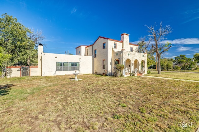 2318 Dallas St, San Angelo, TX 76901 - rear view of house with fence, a chimney, a yard, and stucco siding
