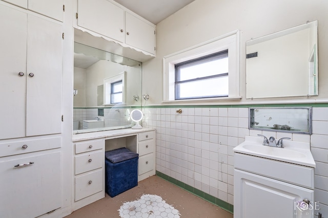 2318 Dallas St, San Angelo, TX 76901 - bathroom with vanity, tile walls, a healthy amount of sunlight, and a wainscoted wall
