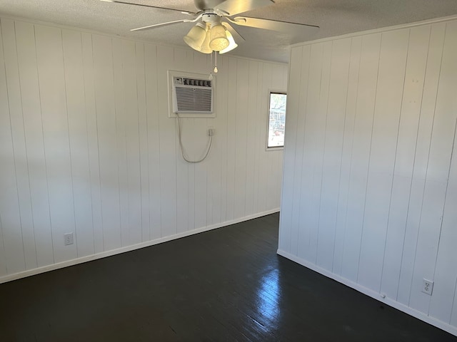 spare room featuring ceiling fan, dark hardwood / wood-style floors, a wall unit AC, and a textured ceiling