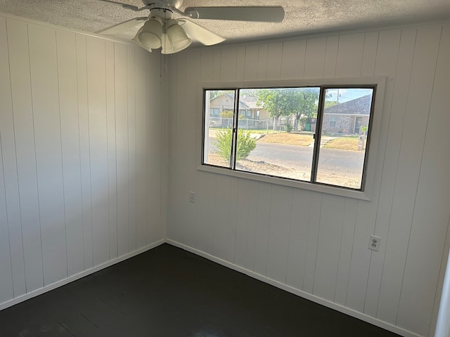 spare room with ceiling fan, plenty of natural light, and a textured ceiling