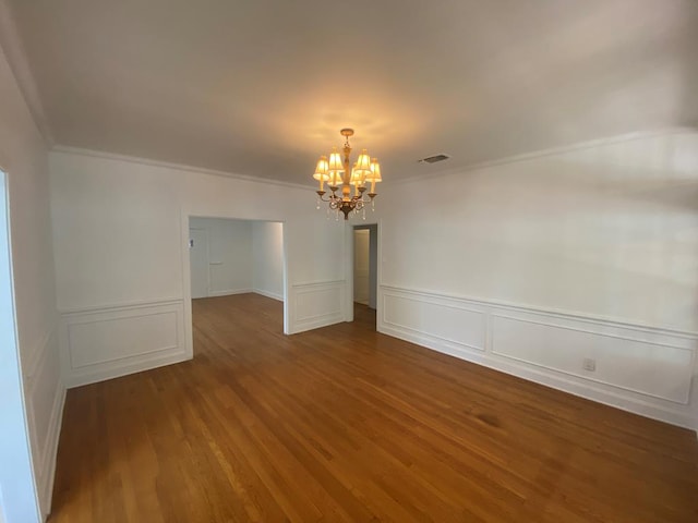 1001 S David St, San Angelo, TX 76903 - spare room with a chandelier, ornamental molding, wood finished floors, a decorative wall, and wainscoting
