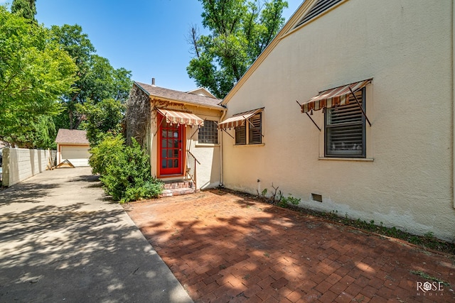 1510 Shafter St, San Angelo, TX 76901 - view of home's exterior with an outbuilding, stucco siding, crawl space, a detached garage, and entry steps