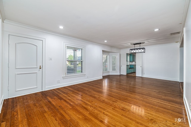 1510 Shafter St, San Angelo, TX 76901 - unfurnished living room featuring ornamental molding, wood finished floors, recessed lighting, and a chandelier