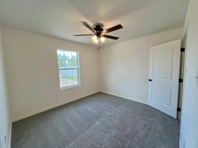 carpeted spare room featuring ceiling fan