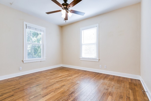 empty room featuring plenty of natural light, hardwood / wood-style floors, and ceiling fan