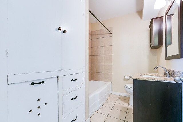 full bathroom featuring vanity, tiled shower / bath, tile patterned floors, and toilet