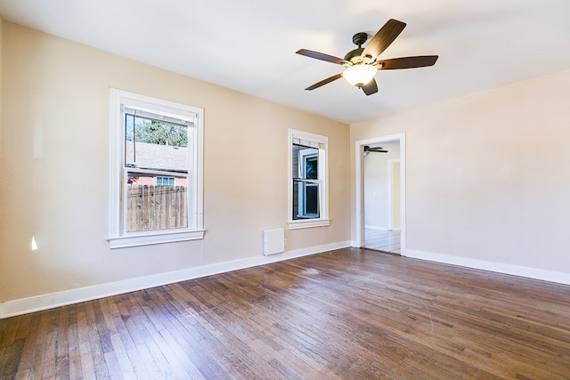 unfurnished room featuring dark wood-type flooring and ceiling fan