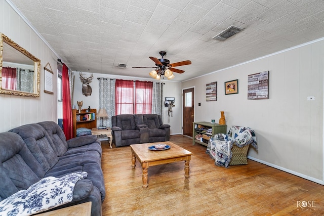 living room featuring wood-type flooring, ornamental molding, and ceiling fan