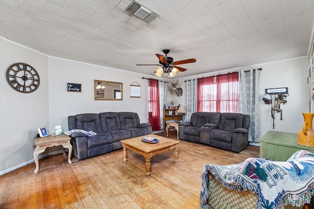 living room featuring hardwood / wood-style flooring, ornamental molding, and ceiling fan