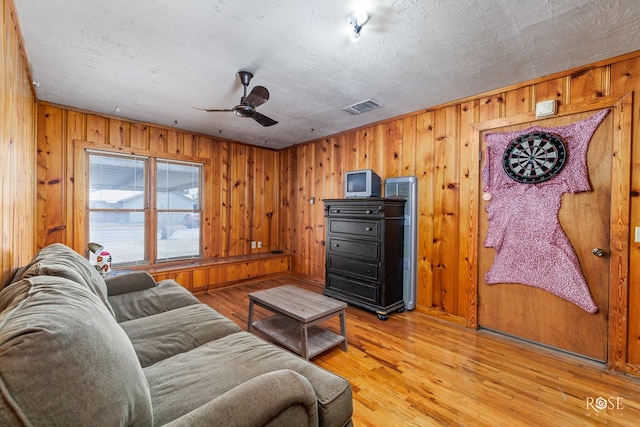 living room with ceiling fan and light hardwood / wood-style flooring