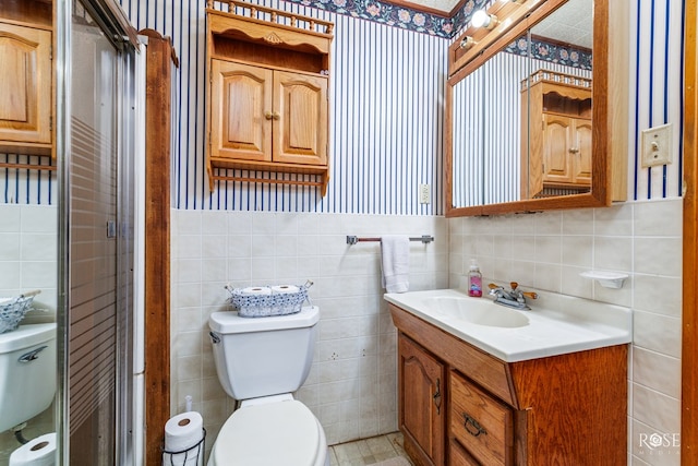 bathroom featuring vanity, toilet, and tile walls