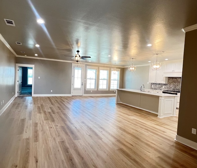 unfurnished living room with ornamental molding, a healthy amount of sunlight, and light hardwood / wood-style floors