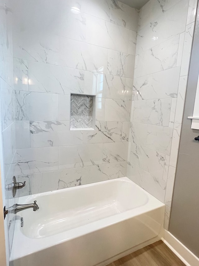 bathroom featuring hardwood / wood-style flooring and tiled shower / bath combo