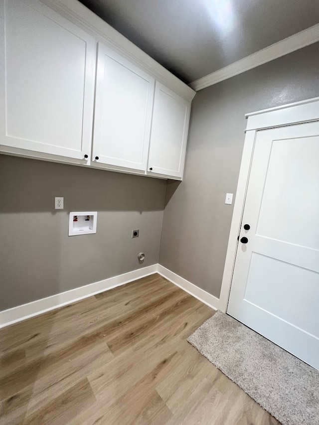 laundry room with electric dryer hookup, hookup for a washing machine, cabinets, ornamental molding, and light wood-type flooring