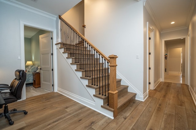 staircase featuring crown molding and hardwood / wood-style floors