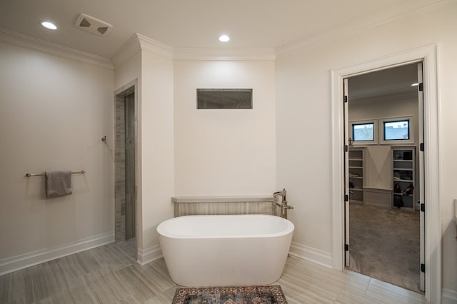 bathroom with a bath and crown molding