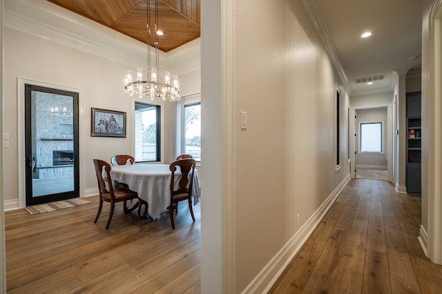 dining space featuring crown molding, hardwood / wood-style flooring, and a chandelier