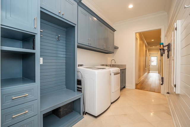 washroom with sink, crown molding, cabinets, and independent washer and dryer