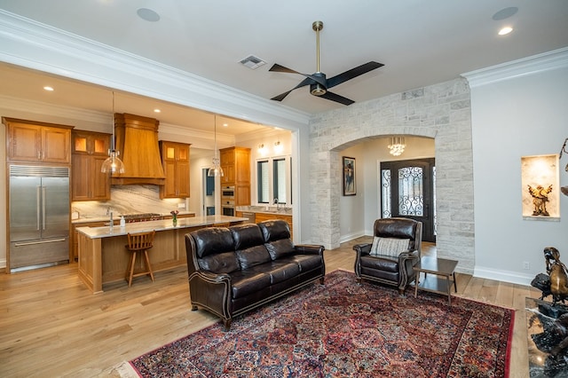 living room featuring ceiling fan, ornamental molding, sink, and light hardwood / wood-style floors