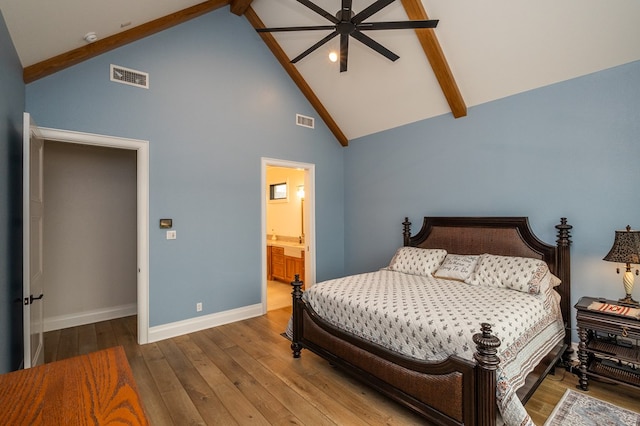 bedroom with ceiling fan, beam ceiling, high vaulted ceiling, connected bathroom, and wood-type flooring