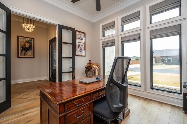 office space featuring crown molding, plenty of natural light, ceiling fan with notable chandelier, and light wood-type flooring