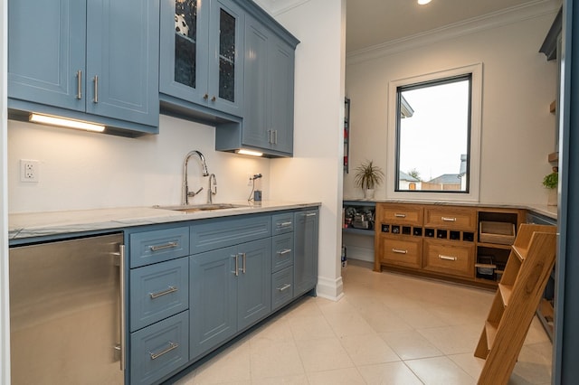 kitchen with sink, crown molding, blue cabinetry, fridge, and light stone counters