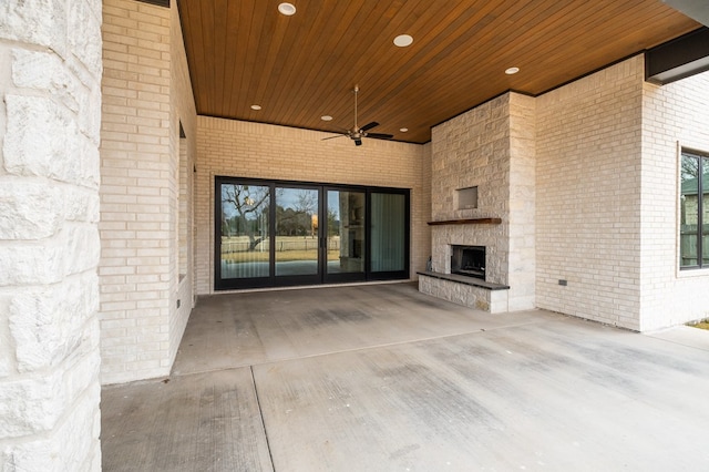 view of patio / terrace featuring ceiling fan and an outdoor stone fireplace