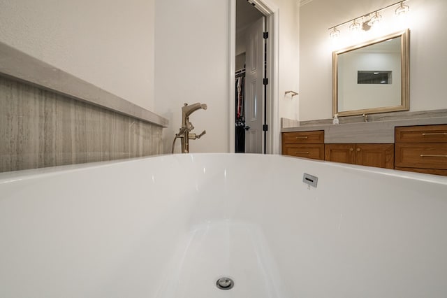 bathroom with vanity and a tub to relax in