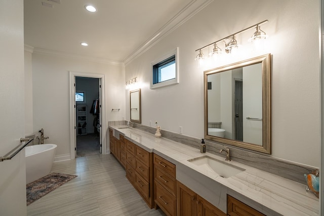 bathroom featuring vanity, crown molding, and a bathing tub